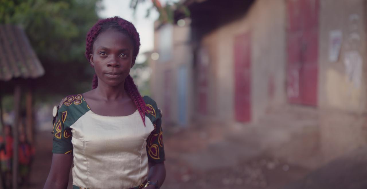 A smiling woman walking down a street