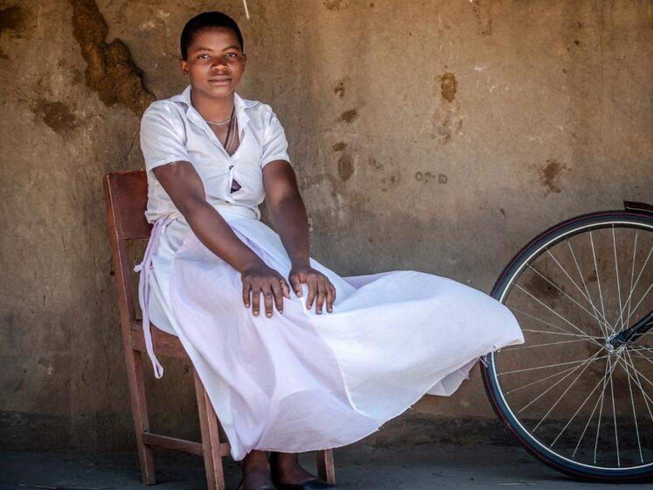 Girl in white dress beside a bicycle