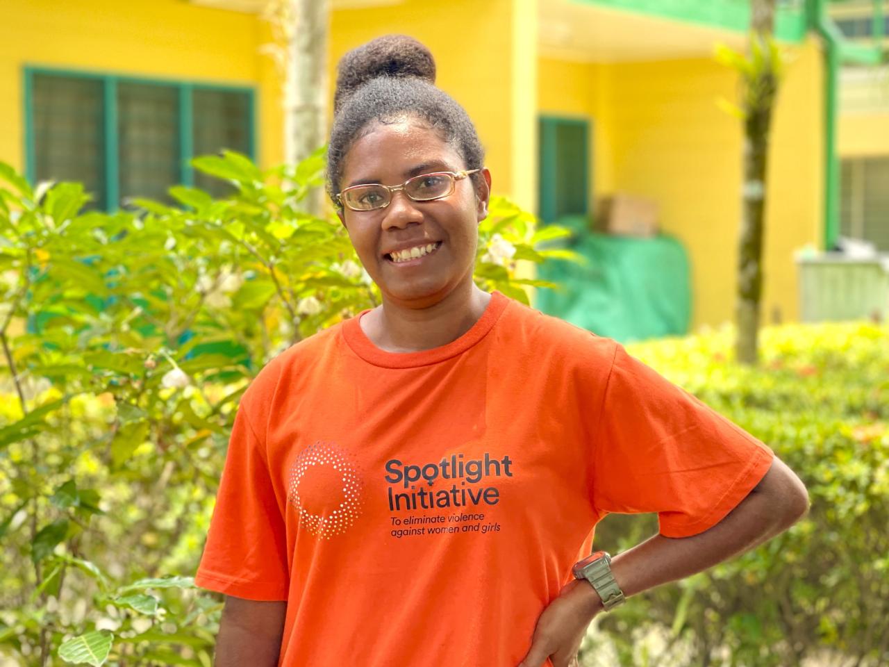 Smiling woman in an orange Spotlight branded t-shirt