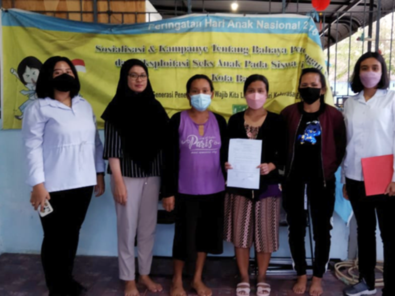 six masked women stand in front of sign