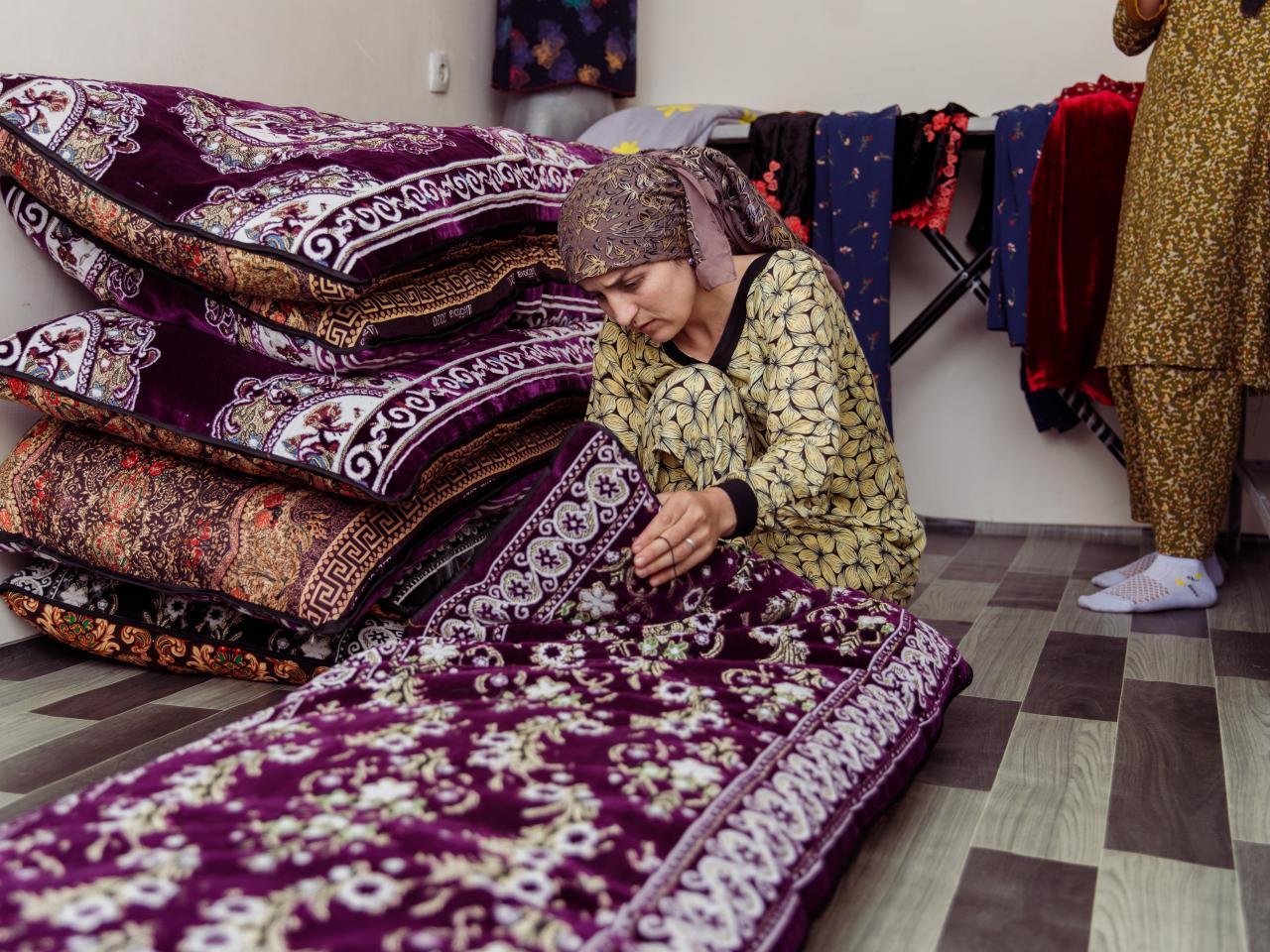 Woman inspecting decorative rugs