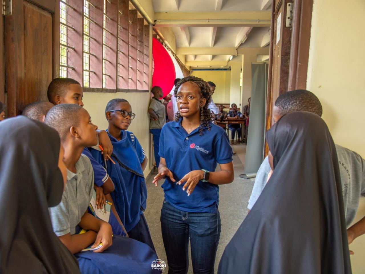 Woman in blue t-shirt speaking with youth