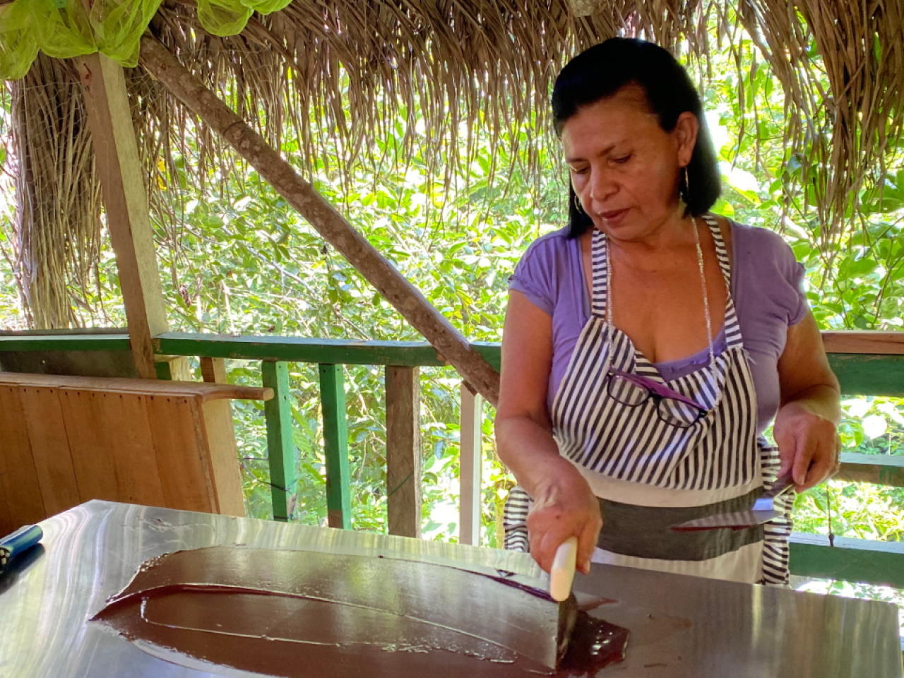 A woman in apron spreads chocolate with spatula