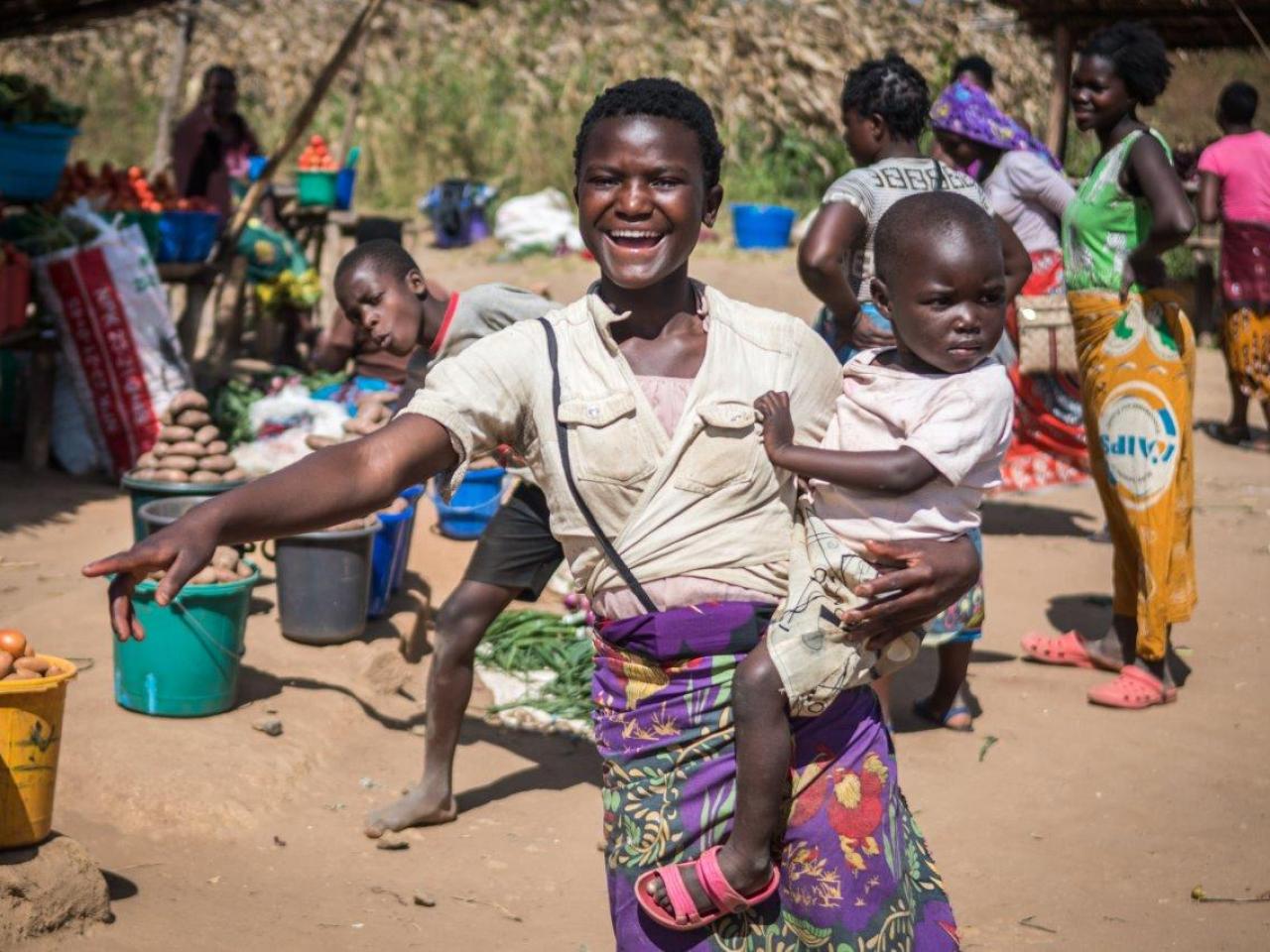 A smiling woman holds her child