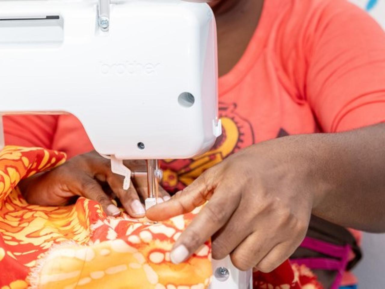 Close up of hands sewing garment on sewing machine