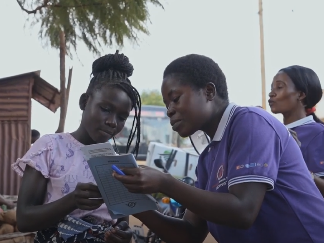 Two girls in street looking at brochure