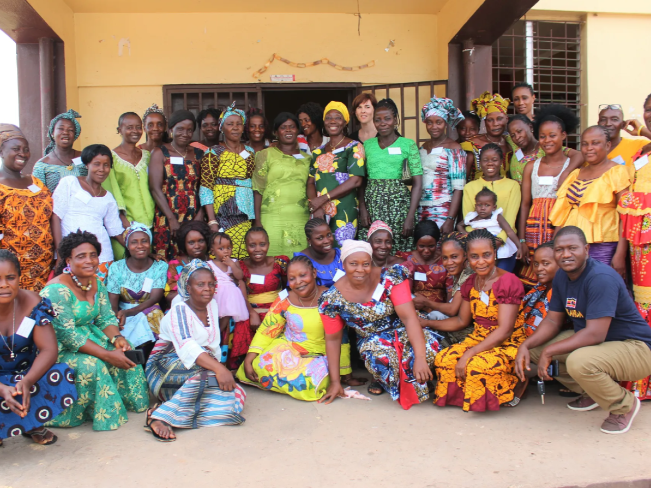 A group of women smiling in front of a building