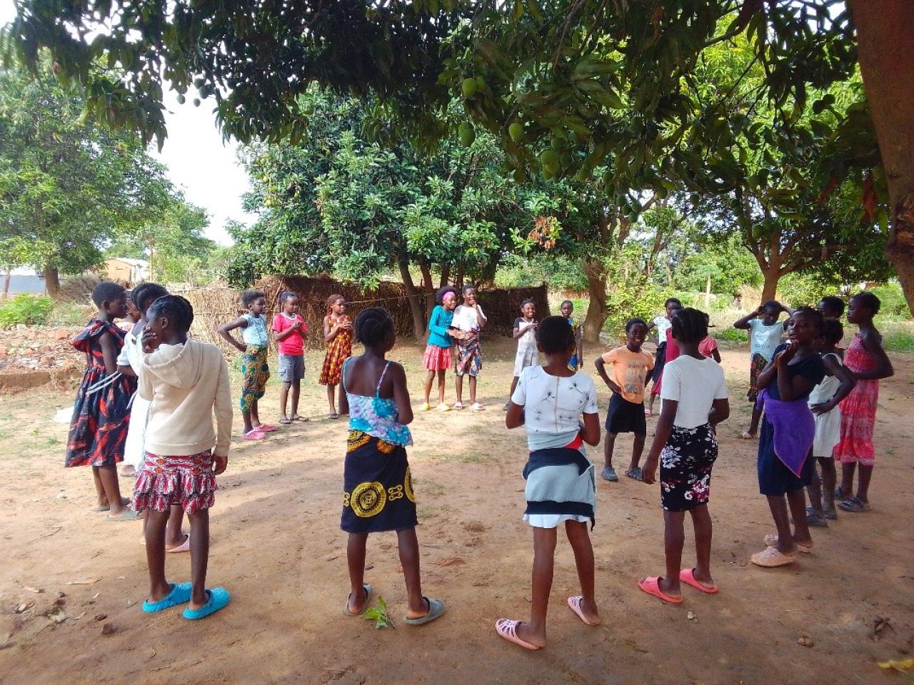 About 20 girls gather in a circle under a Mango tree in Chinsali district as they engage in a team building game.