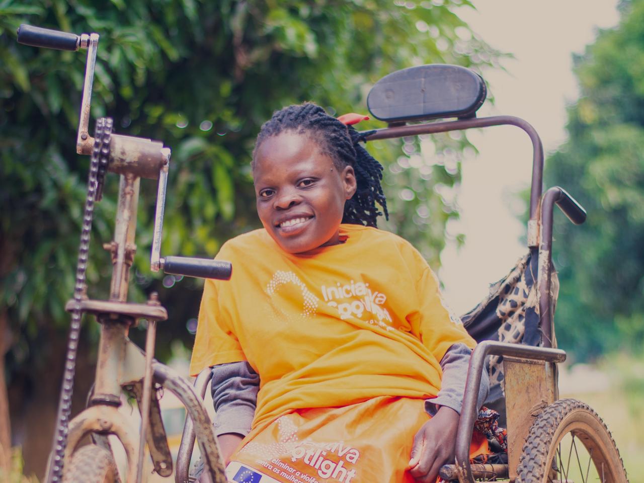 Smiling woman in orange t-shirt in wheelchair