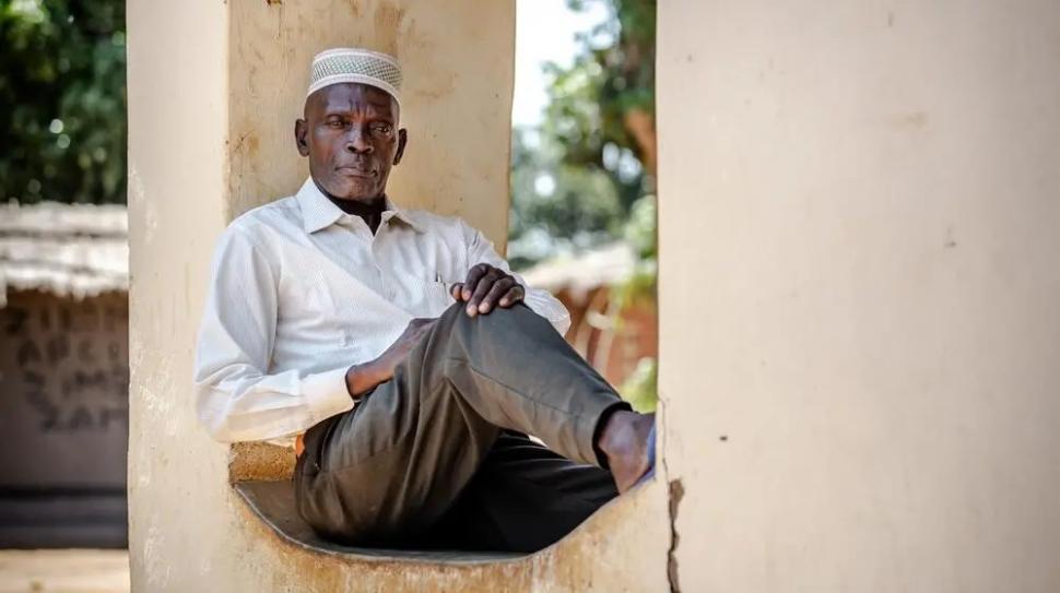 Portrait of a man in a white shirt seated outdoors