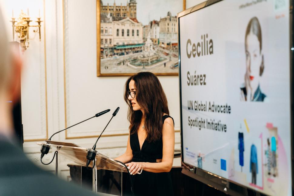 Woman in black dress speaking into microphone