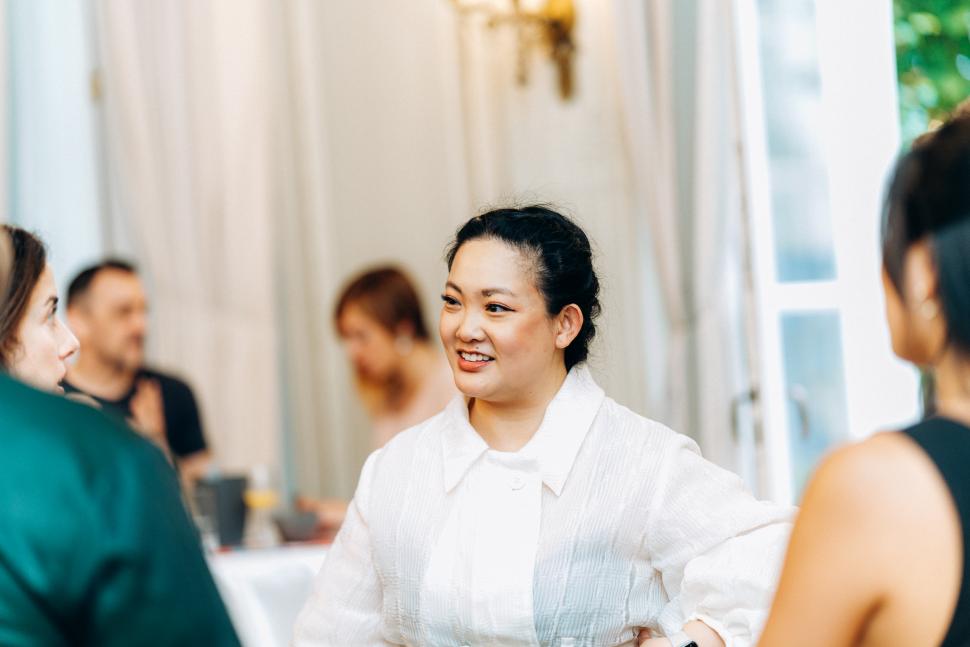 Woman in white dress chats with crowd