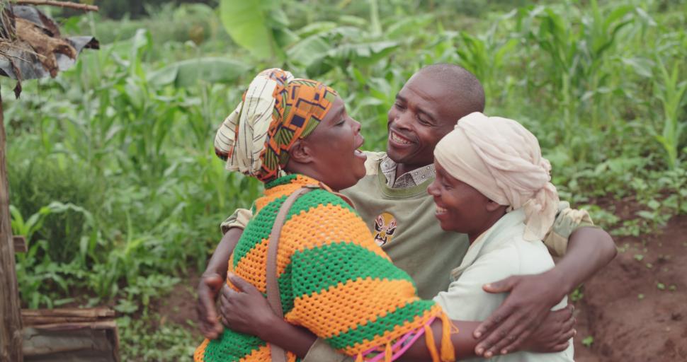 A woman hugging a couple