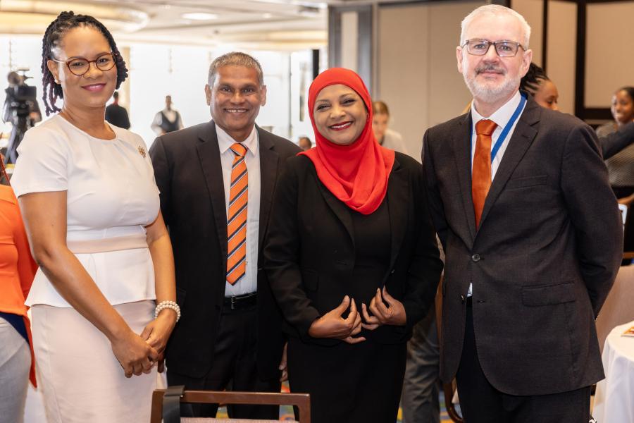 Four smiling men and women in business attire