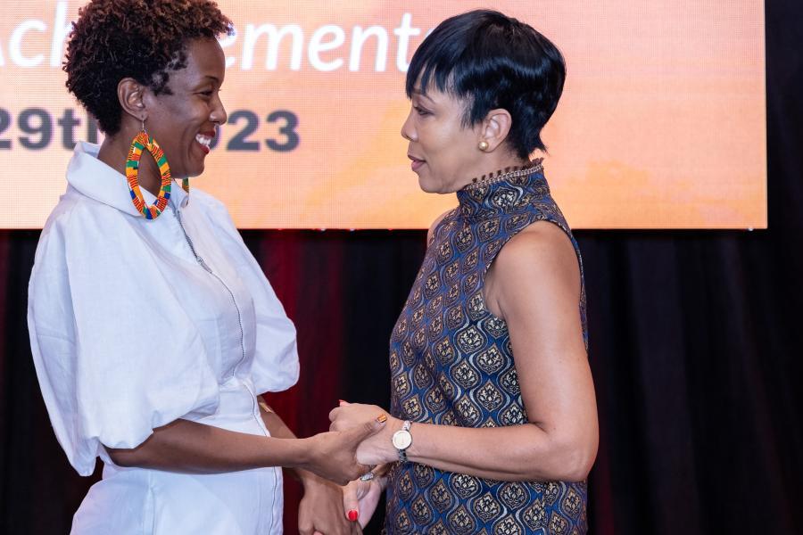 Two women greeting each other on stage.