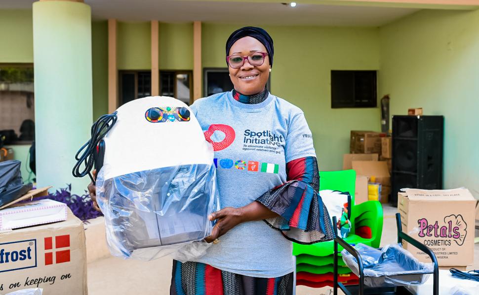 Smiling woman holds a large piece of equipment
