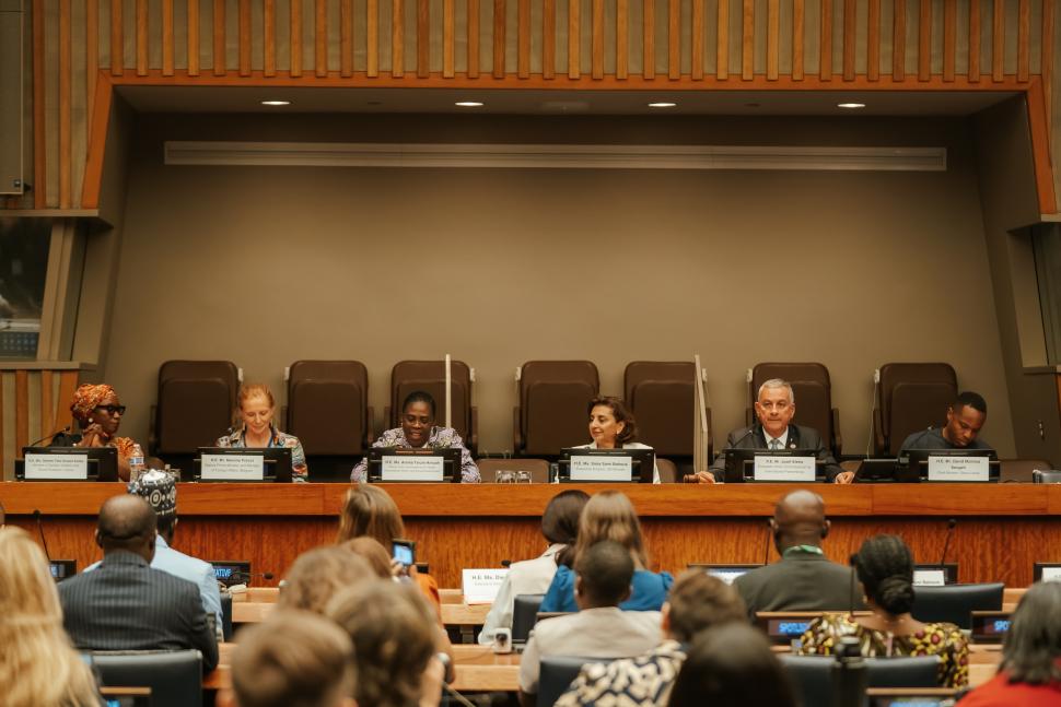 Panellists sit in front of crowd