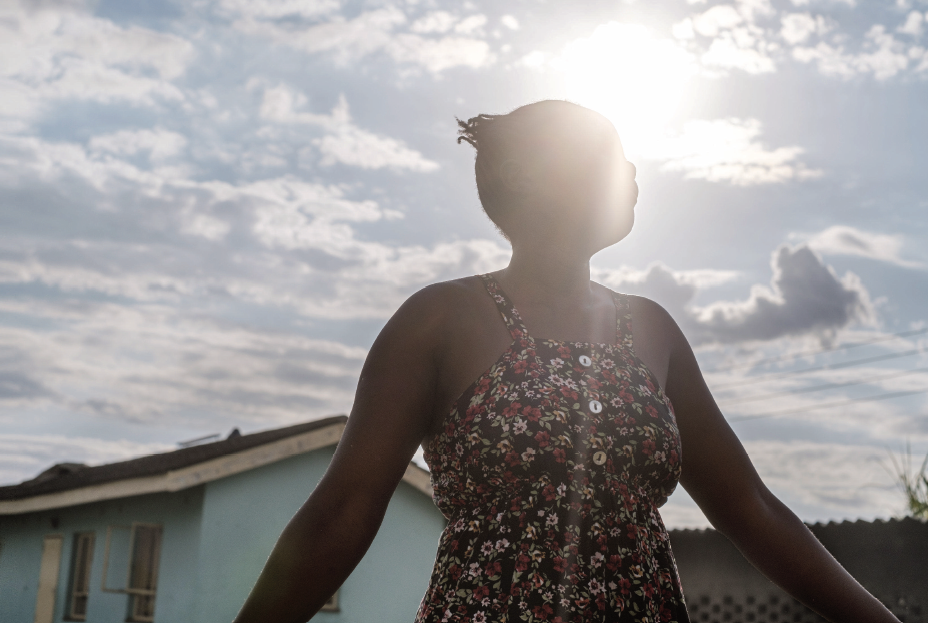 Tadiwa looks upward with her face obscured by sunlight