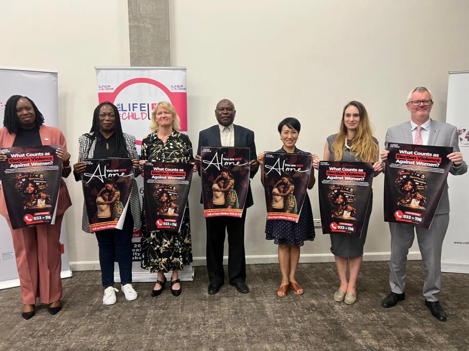 A photo of 3 men and 3 women holding posters during the launch of The Violence Against Women in Elections Reporting Mechanism.