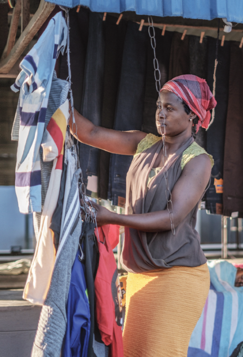 Juliet hangs clothes outside her stall