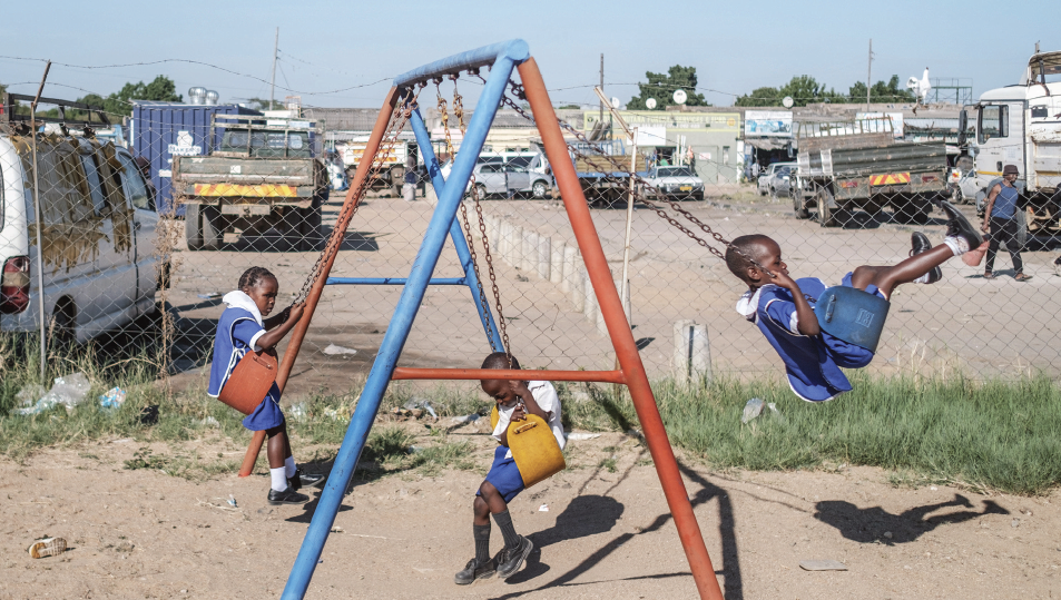 Three children playing on swings