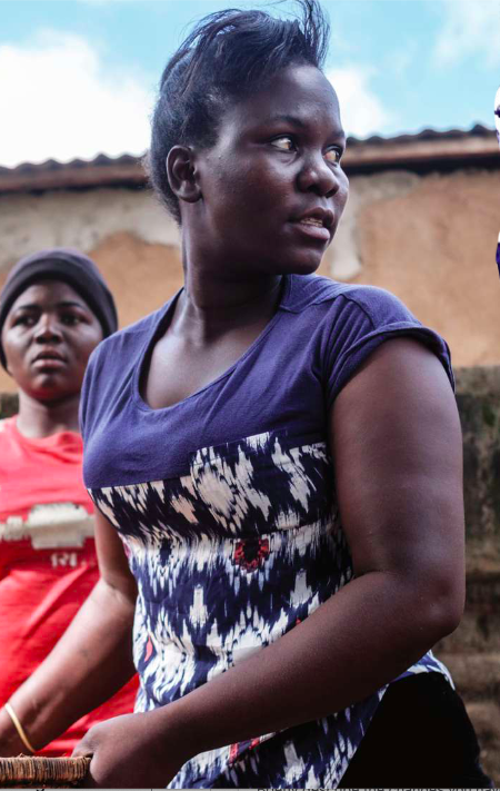 Elestina Joseph stands outside in a purple t-shirt.