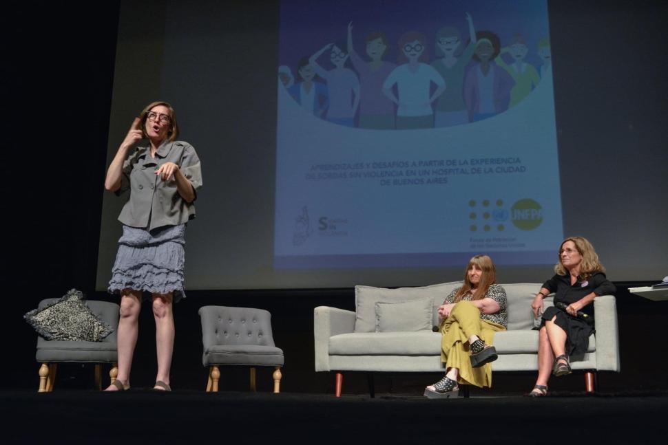 A woman signing on stage at an event