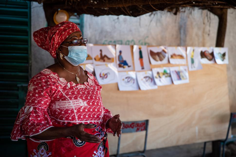 Masked woman standing in front of posters