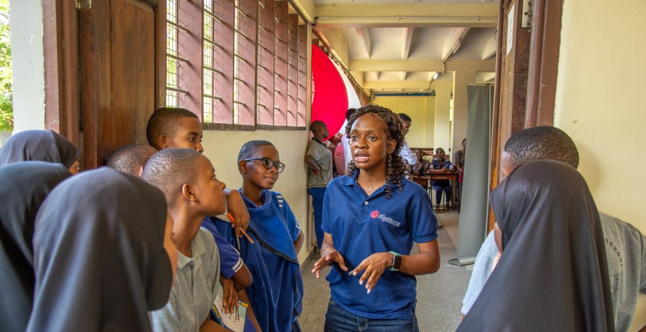 Woman in blue t-shirt speaking with youth