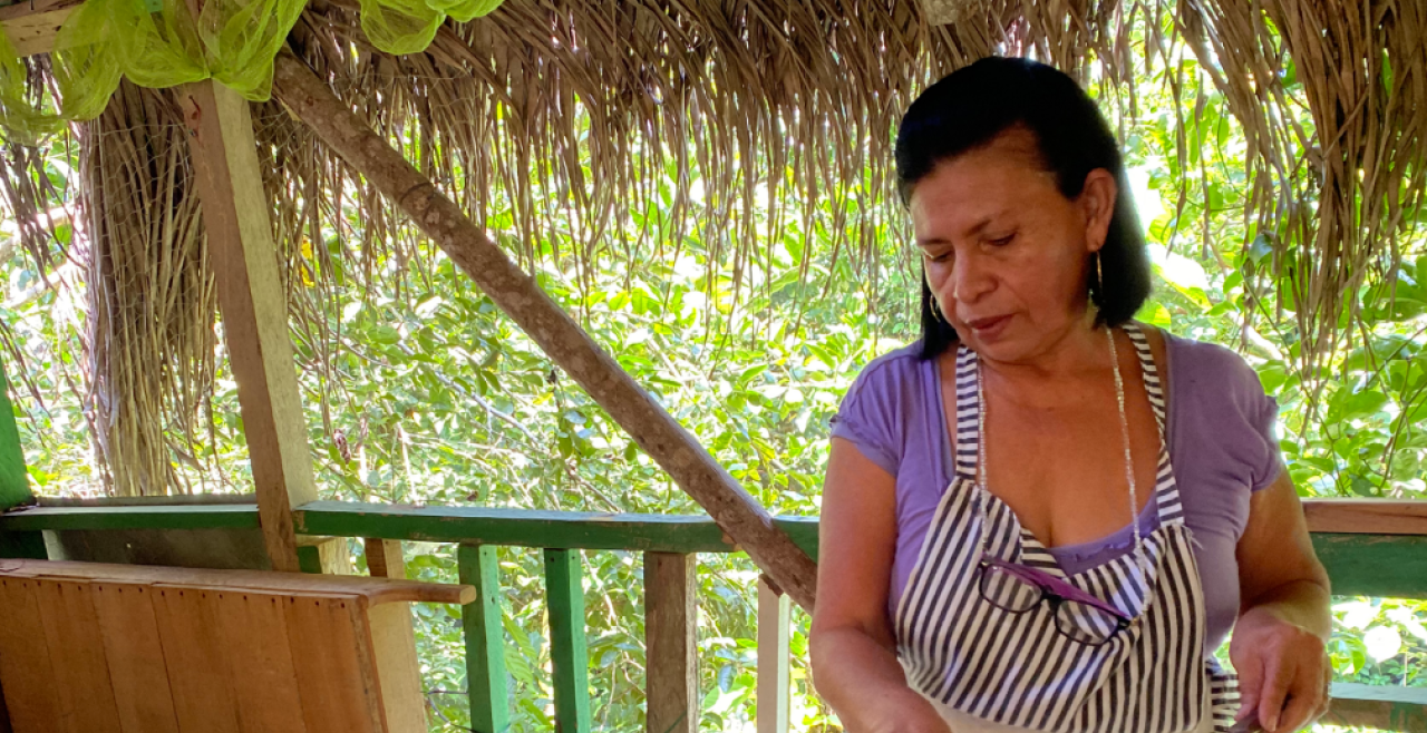 A woman in apron spreads chocolate with spatula