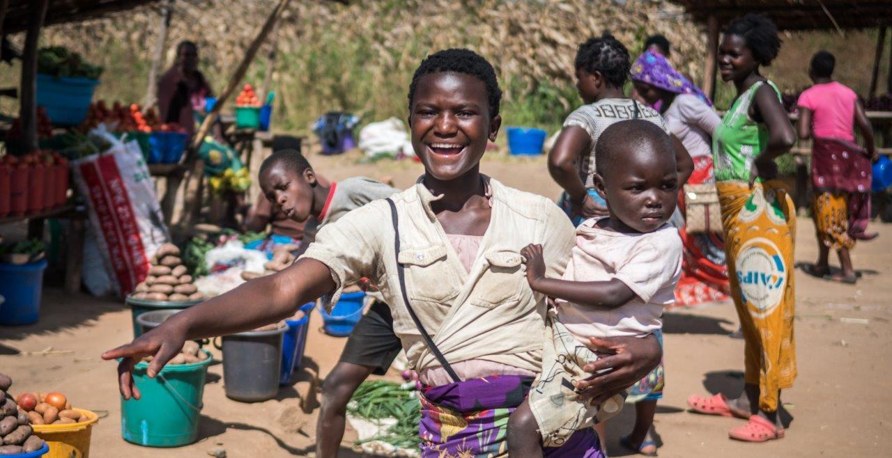 A smiling woman holds her child