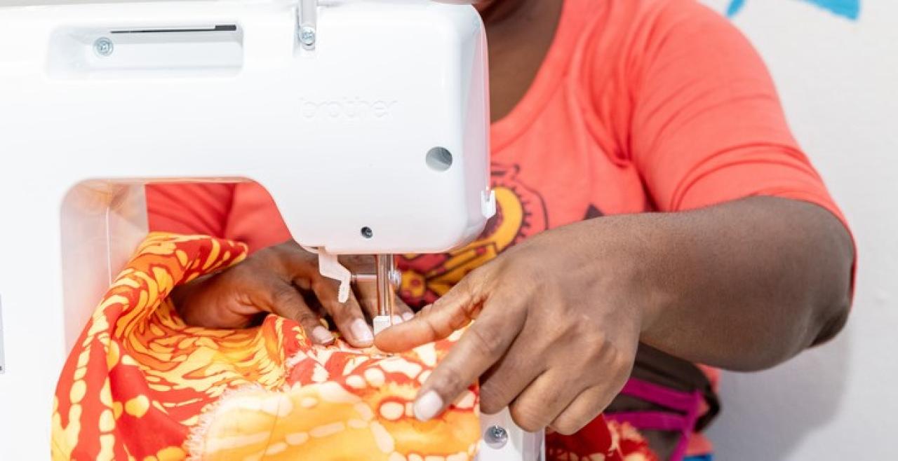 Close up of hands sewing garment on sewing machine