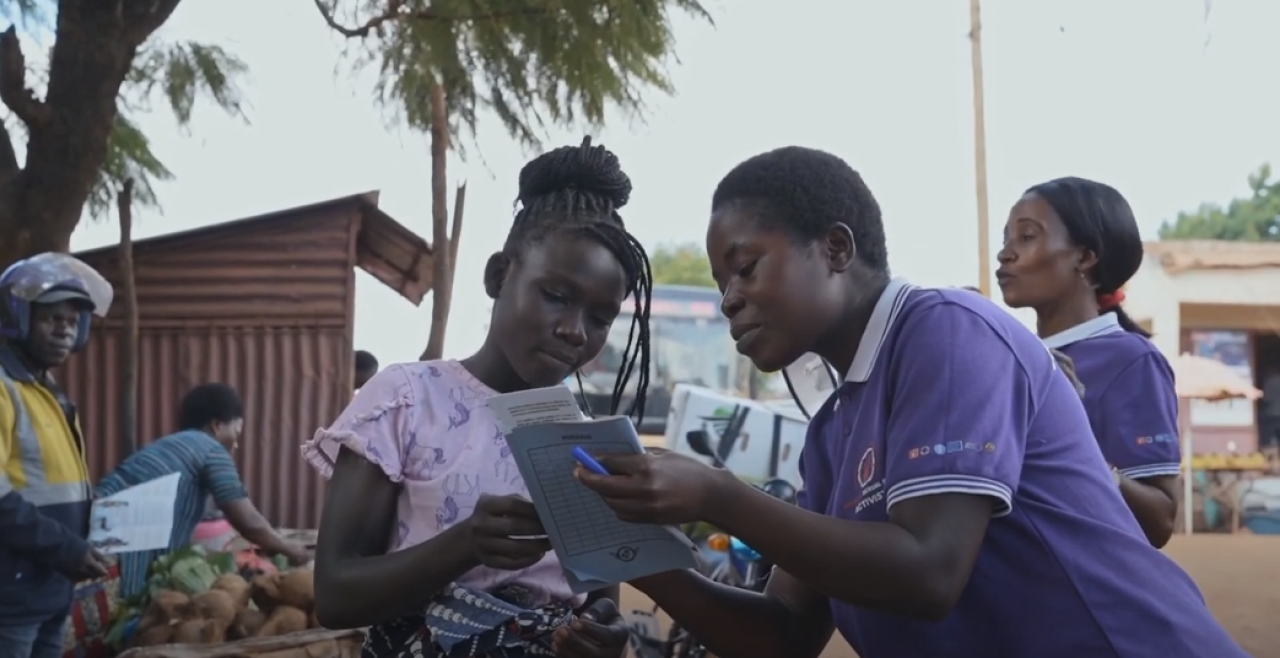 Two girls in street looking at brochure