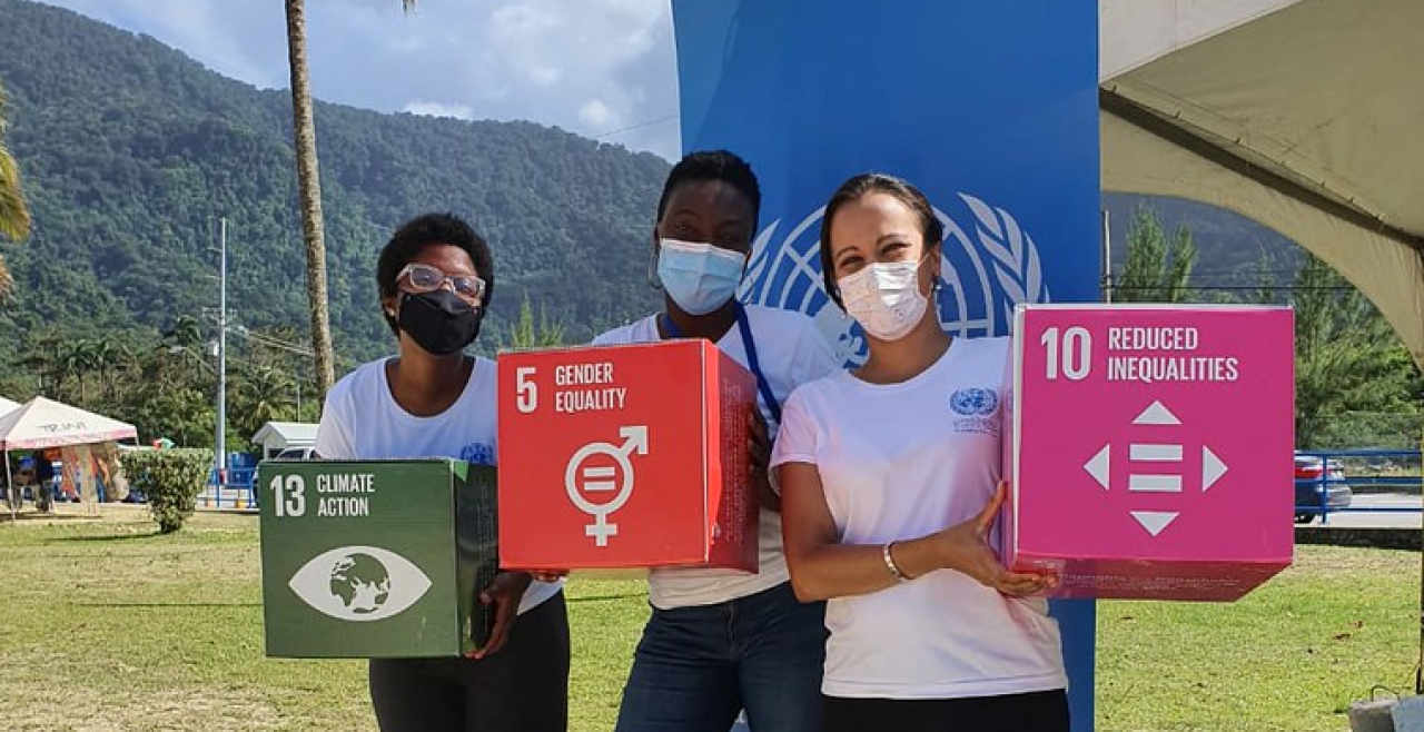 Three women hold cubes with different SDGs written on them