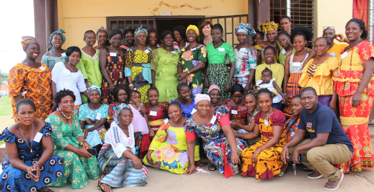 A group of women smiling in front of a building