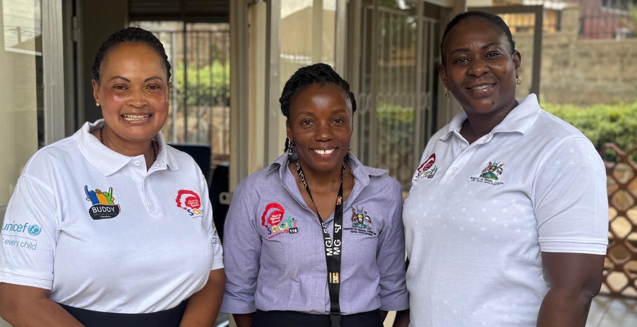 Three female sauti counsellors stand in front of their building