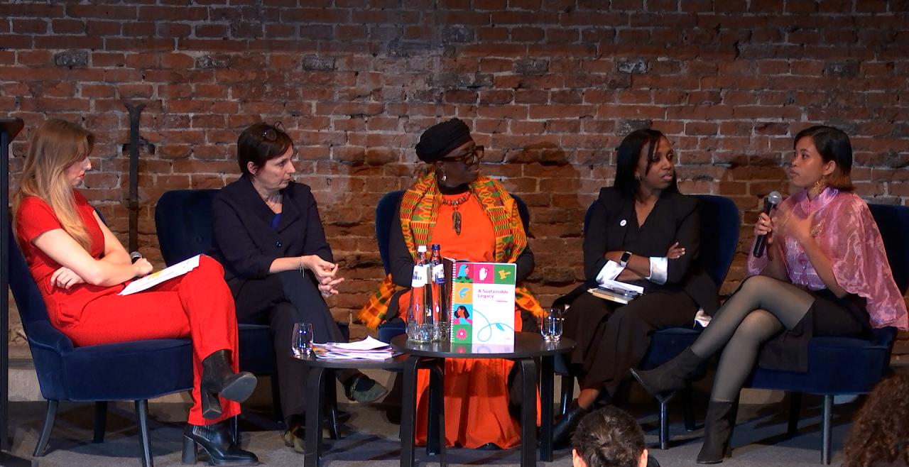 five women seated on stage