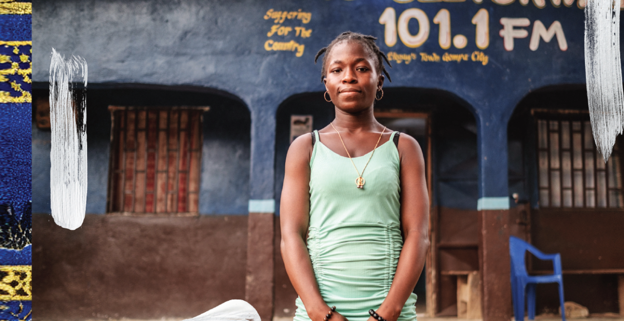 A woman in a green dress stands outside a building that reads Radio Sletorwah