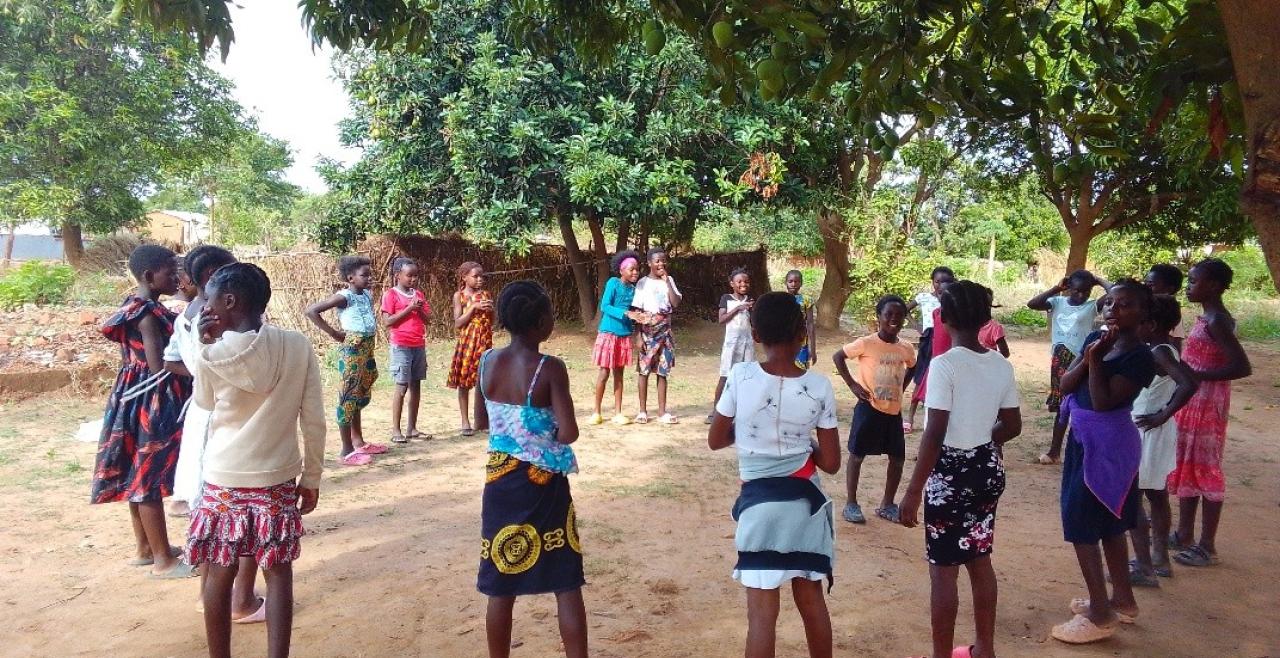 About 20 girls gather in a circle under a Mango tree in Chinsali district as they engage in a team building game.