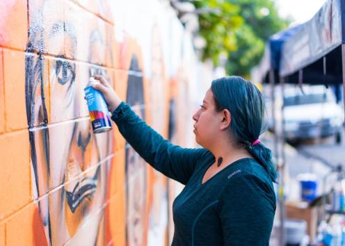 Woman spray painting a mural
