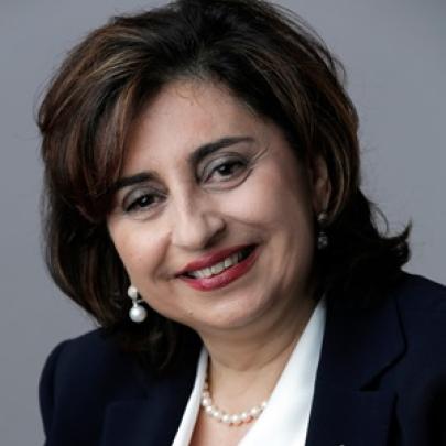 A smiling woman in a white blouse and black jacket